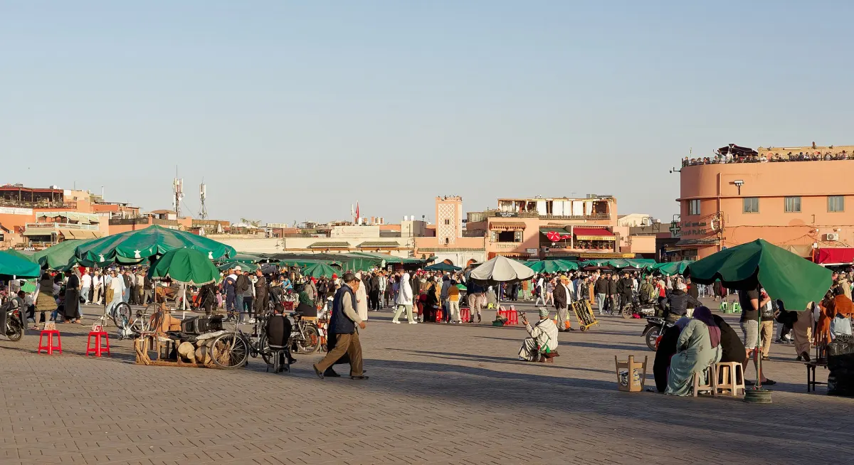 Food stalls, green parasols and crowds filling Jemaa el-Fna square in the late afternoon